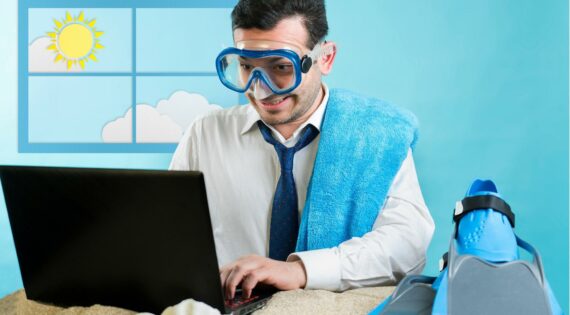 Ein Mann im Anzug mit Taucherbrille arbeitet an einem Laptop.